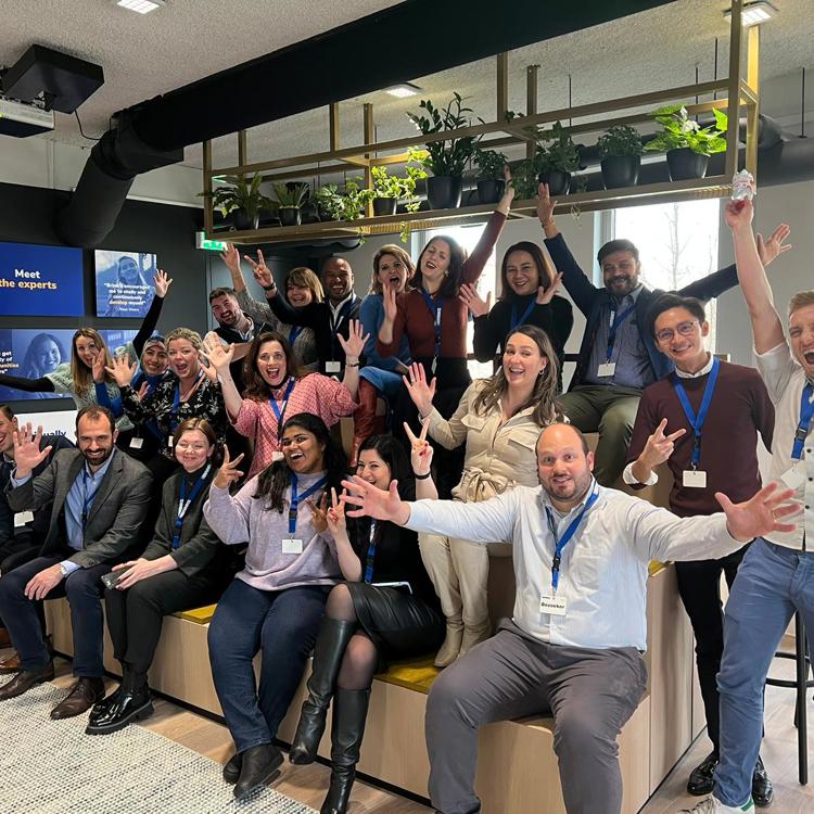 A group of 20 people form all over the world excited and smiling